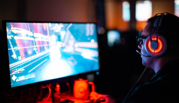 person using computer playing FPS game