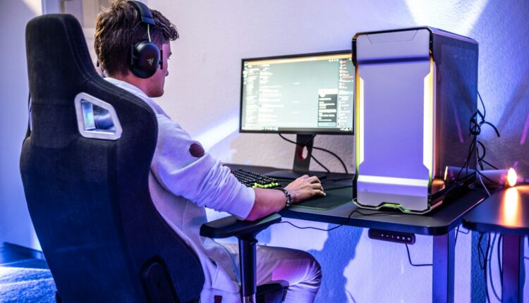 a man sitting in front of a computer on a desk